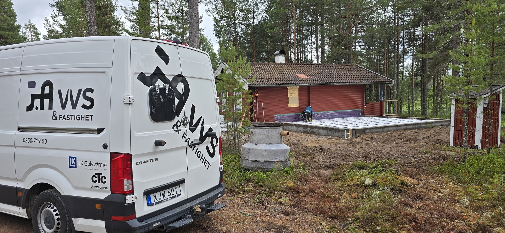 JA VVS servicebil framför ett faluröd hus i skogen