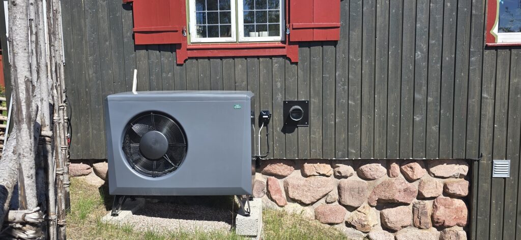Luft/vattenvärmepump utanför ett faluröd hus med stengrund