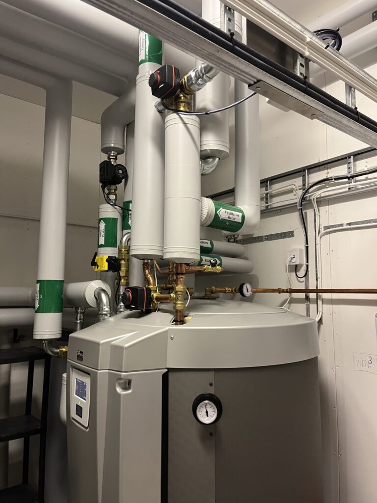 Värmepump och ackumulatortank i ett pannrum